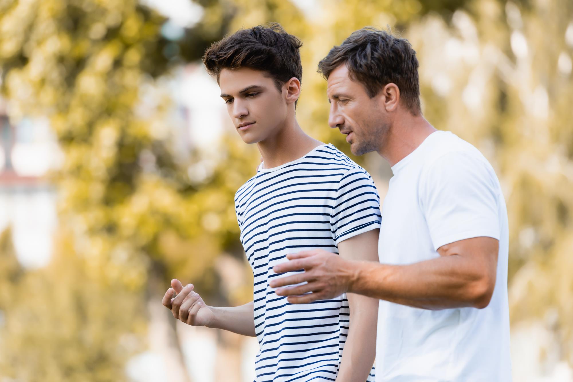 Teen boy talking to adult man